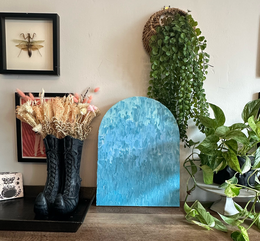 Decorative items including a blue arch, black boots with flowers, and plants on a shelf.